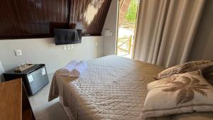 una camera da letto con un letto, una tv e una finestra di Chales da Kitanda Petit a Teresina