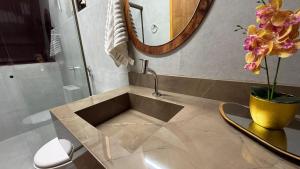 bagno con lavandino, specchio e fiori di Chales da Kitanda Petit a Teresina Altre 20 foto