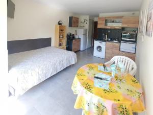 ein Schlafzimmer mit einem Tisch mit einem Bett und einer Küche in der Unterkunft A 100m de la plage A3, Rez-de-chaussee in Cap d'Agde