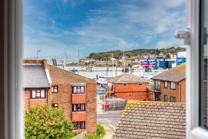 Blick auf eine Stadt mit Gebäuden und Hafen in der Unterkunft 3-BR Luxe Cowes Cottage Harbour Views, Sleeps 6, with Private Garden - LONG TERM STAY SPECIAL OFFER AVAILABLE! - by Blue Puffin Stays in Isle of Wight