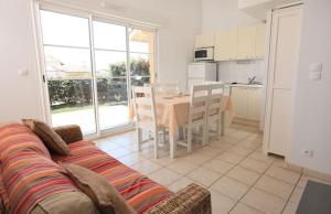 a living room with a couch and a table with chairs at Résidence Belle Dune Blanche, maisons et appartements in Biscarrosse-Plage