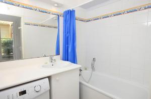 a bathroom with a sink and a tub and a mirror at Résidence Belle Dune Blanche, maisons et appartements in Biscarrosse-Plage +41 photos