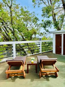 two picnic tables on a patio with a fence at Dinewa Apartment in Aluthgama
