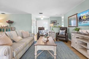 ein Wohnzimmer mit Sofa und Tisch in der Unterkunft Waterfront Bliss with Saltwater Pool, Hot Tub & Dockside Fire Table - Kathys Cottage - Roelens in Cape Coral