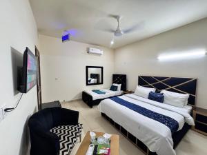 a bedroom with a bed and a tv and a couch at Holiday Inn islamabad in Islamabad