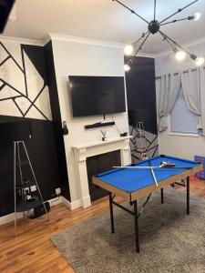 a room with a ping pong table and a fireplace at Stylish 3 BR home & Game room & Family Lounge in Dudley