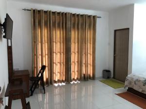 a living room with a large window with curtains at Hotel mango tree nearest Adam's peak in Adams Peak