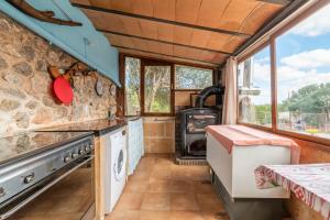 a kitchen with a stove and a stone wall at Finca Son Matginet in Sineu