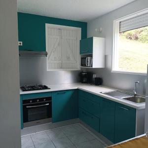 a kitchen with blue cabinets and a sink at Appartement charmant au Gosier avec jardin de 68 m² in Mare Gaillard