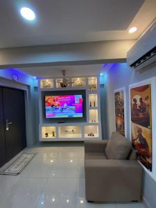 een woonkamer met een bank en een flatscreen-tv bij Beatrix Valley, 1 Bedroom Modern Luxury in Tema