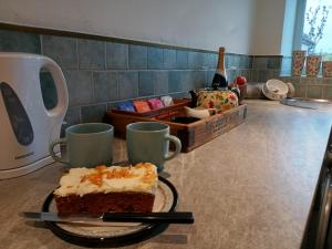 a piece of cake on a counter with two cups at The Studio at St Cleer in Chippenham