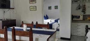 a kitchen with a table and a bed in a room at Florence Cottage in Beddegama