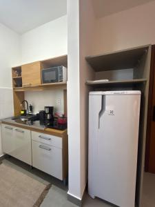 une petite cuisine avec un réfrigérateur et un micro-ondes dans l'établissement Compact Home Campinas, à Campinas 22 autres photos