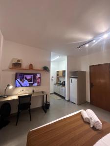 une chambre avec un lit, un bureau et une télévision dans l'établissement Compact Home Campinas, à Campinas