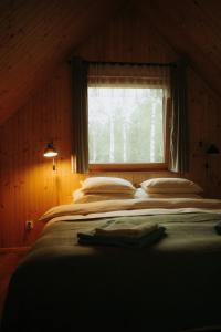 a large bed in a room with a window at Miło las widzieć in Ciwoniuki