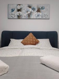 a bed with a brown pillow and flowers on it at Iconic Zuza in Gran Alacant