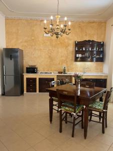 a kitchen with a wooden table and a refrigerator at Mimí Holiday Home in Torre Nubia