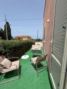 a patio with chairs and tables on a building at Mimí Holiday Home in Torre Nubia