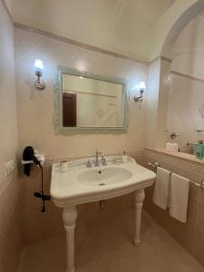 a bathroom with a sink and a mirror and a tub at Mimí Holiday Home in Torre Nubia