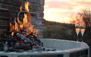 a fire pit with two glasses of wine at Tierpoort Barn in Mountain in Tierpoort