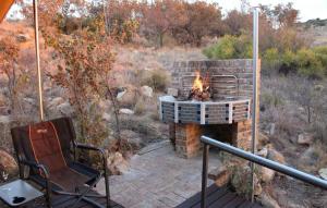 a patio with a fire pit and a chair at Tierpoort Barn in Mountain in Tierpoort