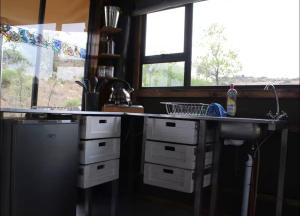a kitchen with a counter and a sink and windows at Tierpoort Barn in Mountain in Tierpoort