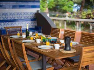 a wooden table with plates of food and a bottle of wine at Finca Fuente Laurel in Arucas
