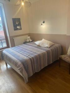a bedroom with a bed with a dog sitting on it at cocon beaujolais in Anse