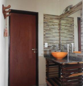 La salle de bains est pourvue d'une porte en bois et d'un lavabo. dans l'établissement Los Cantaros, à Santa Rosa de Calamuchita