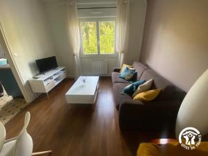 a living room with a couch and a coffee table at Gîte de la Croix de l'Aveyron in Laguépie
