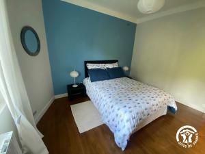 a bedroom with a bed with a blue wall at Gîte de la Croix de l'Aveyron in Laguépie