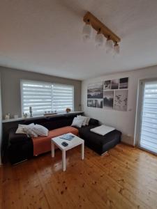 a living room with a couch and a table at Haus Fuchsbau, Familienzeit und Fokus im Grünen in Kurtscheid