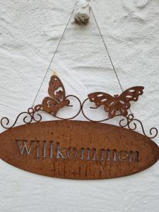 a sign hanging on a wall with butterflies on it at Haus Fuchsbau, Familienzeit und Fokus im Grünen in Kurtscheid
