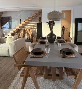 a table with plates and glasses on it in a living room at Casa Troia in Alhaurín de la Torre