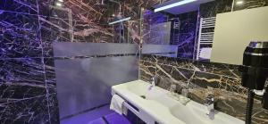 a purple bathroom with a sink and a mirror at Berg'hotel in Socx +11 photos