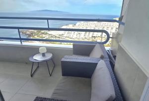 einen Balkon mit einer Bank und Meerblick in der Unterkunft Home2Book Relaxing Coastal Studio in Adeje in Adeje