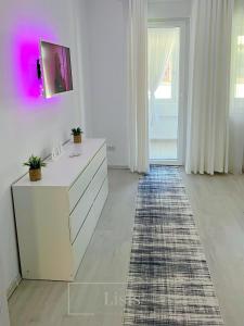 a white room with a dresser and a rug at Lisis Premium Apartments in Reşiţa