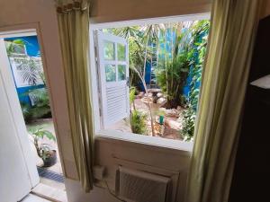 a window with a view of a garden at Pousada Mandala - Búzios in Búzios