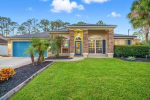 a house with a green lawn in front of it at Castaway Cove | Palm Coast in Palm Coast