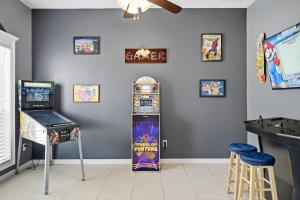 a room with a pinball machine and a game at Castaway Cove | Palm Coast in Palm Coast