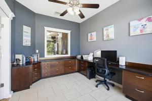 an office with a desk with a computer and a fan at Castaway Cove | Palm Coast in Palm Coast +42 photos