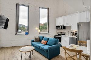 ein Wohnzimmer mit einer blauen Couch und einer Küche in der Unterkunft Nola Retreat Next To Frenchmen & French Quarter in New Orleans