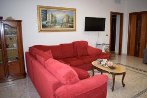 a living room with a red couch and a table at Valle holiday casa vacanza in Locorotondo