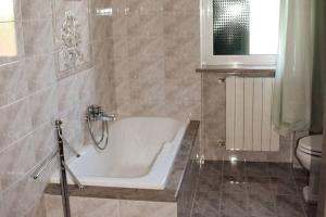 a bathroom with a bath tub and a toilet at Valle holiday casa vacanza in Locorotondo +18 photos