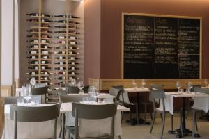 a dining room with tables and chairs and a chalkboard at Ruffini Boutique Rooms in Ascoli Piceno