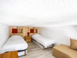 Cette chambre comprend deux lits et un canapé. dans l'établissement Studio 3 pers, balcon, proche pistes et commerces, animaux acceptés - FR-1-411-493, à Arc 1600