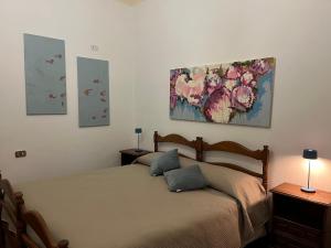a bedroom with a bed and three paintings on the wall at Villa Allegrini in Segni