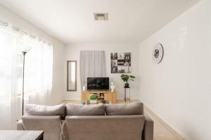 a living room with a couch and a tv at West Palm Beach Hideaway J2A in Lantana