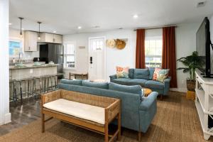 a living room with two blue couches and a kitchen at Downtown Retreat, 5BR Game Room & Pet Friendly in Wilmington