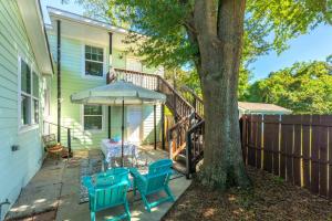 a patio with a table and an umbrella and a tree at Downtown Retreat, 5BR Game Room & Pet Friendly in Wilmington